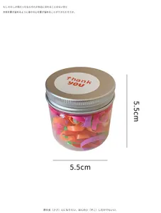 Macro detail of multi-colored kids' hair ties in a clear 5.5cm jar with gold lid