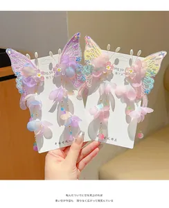 Detailed view of hand-held butterfly embroidery hair clips with long beaded tassels