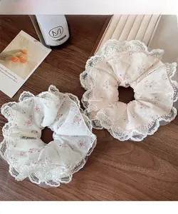 Detalle de coleteros florales con bordes de encaje blanco en fondo de madera