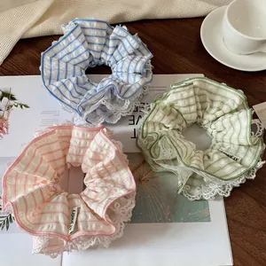 Three plaid lace scrunchies in blue pink and mint green on a rustic wooden table