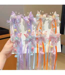 Detailed view of four butterfly hair clips with long ribbons and colorful beads