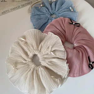 Elegant pleated hair scrunchies with satin bows and pearls in white, blue, and pink colors