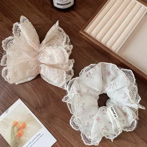 Elegante pinza de lazo de encaje beige y conjunto de coletero floral en mesa de madera