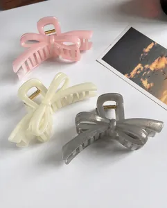 Detail of elegant bow hair claws in pink, cream and grey with shimmering resin finish
