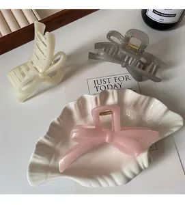 Three elegant bow claw clips in cream, grey and pink colors with glossy finish