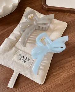 Detail of elegant resin bow hair claws with pearlescent finish and metal springs