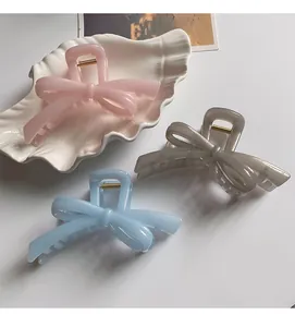 Detailed view of elegant bow hair claws in pink, grey, and blue pearlescent resin