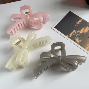Elegant oversized bow hair claws in pink, cream, and glitter grey colors for women