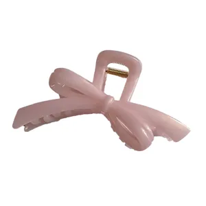 Elegant large light pink bow hair claw clip with a glossy finish for a minimalist hairstyle