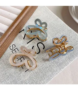 Détails de trois pinces à cheveux papillon en acétate dégradé sur support texturé