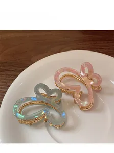 Détails de pinces à cheveux papillon en acétate bleu et rose sur une assiette en céramique