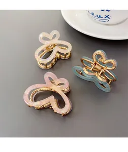 Détail de trois pinces à cheveux papillon en acétate dégradé avec éclat nacré brillant