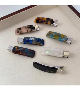Detail view of seven assorted acetate hair clips with golden Barrette La France lettering