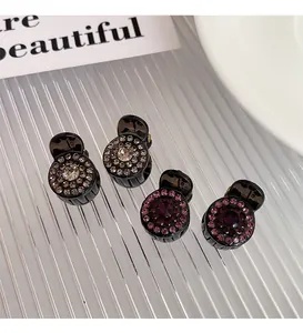 Detail of mini sparkling rhinestone hair claws in a set of four for elegant styling