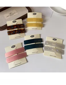 Detail of minimalist rectangular acetate hair clips in tortoise and marble patterns