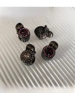 Detailed top view of four mini rhinestone hair clips with deep purple and brown crystals