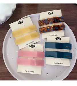 Detail showing acetate barrettes in amber, yellow, pink, and green on display cards