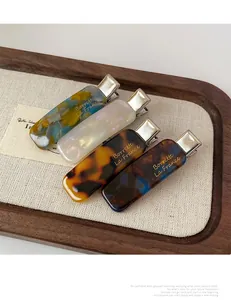 Set of four tortoiseshell and marble acetate hair clips on a premium display tray