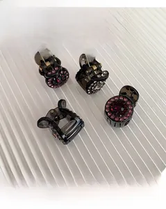 Detail of four mini hair claws with dark resin and sparkling rhinestones for hair styling