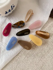 Détail de barrettes goutte en acétate avec inscription dorée France Handmade