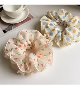 Detail of cream organza hair scrunchies with pink heart and blue polka dot patterns