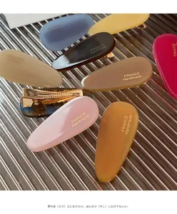 Détail de pinces à cheveux en acétate colorées avec inscription dorée France Handmade