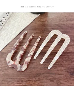Détail de fourches à cheveux en acétate écaille et marbre sur une table en bois