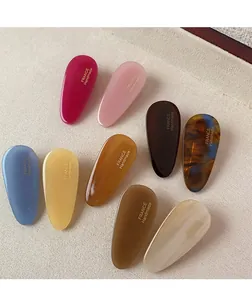 Détail macro de barrettes goutte d'eau en acétate coloré avec inscription dorée fait main