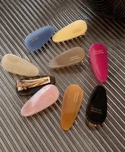 Détails de barrettes colorées en acétate en forme de goutte avec lettrage doré à la main