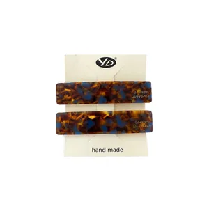 Set of two rectangular acetate hair clips with tortoiseshell pattern and gold lettering
