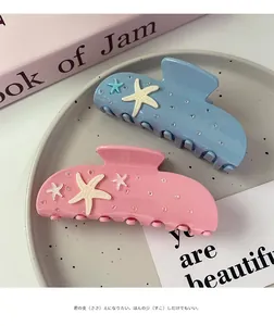 Detail view of colorful starfish hair clips with glitter accents in pink and blue colors