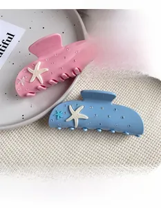 Close-up of pink and blue starfish hair claws with sparkling rhinestones and matte finish