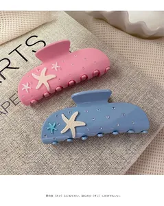 Detailed view of starfish hair clips in pink and blue acetate with subtle glitter finish