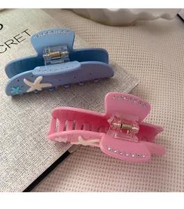 Close-up of pastel starfish hair claws with resin finish and sparkling rhinestones