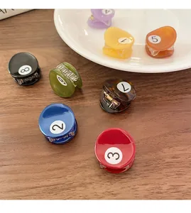 Dettaglio di mini mollette per capelli a forma di palla da biliardo colorate con numeri