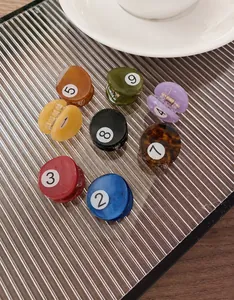 Détail de pinces à cheveux boules de billard colorées avec mini clips numérotés en résine