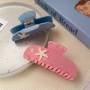 Starfish acetate hair claws in pastel blue and pink with 3D details and pearl accents