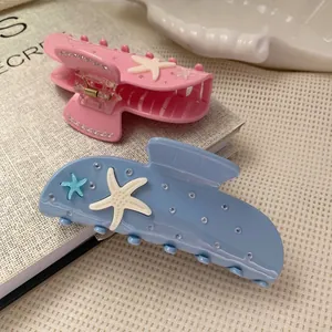 Pink and blue starfish hair claw clips with rhinestones in a lifestyle set