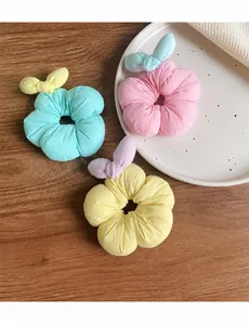 Close-up of three colorful floral fabric hair ties in pink, mint green, and yellow colors