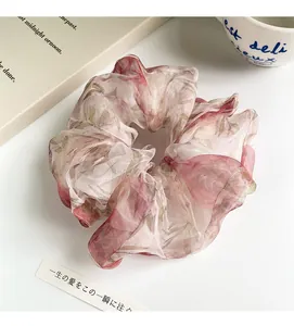 Close-up of floral organza scrunchie with layered fabric texture on white background
