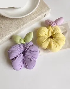 Detailed view of plush floral scrunchies with 3D filling and contrasting bow accents