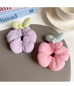 Detail view of floral scrunchies with soft pleated fabric and decorative leaf accents