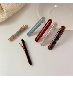Detailed set of six marble and floral pattern acetate hair clips with golden metal base