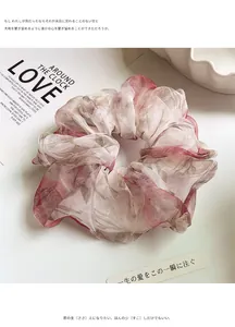 Detail of floral organza scrunchie with soft pink petals and elegant pleated texture