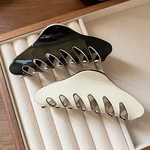 French style large hair claw clips in black and white finish on velvet display tray
