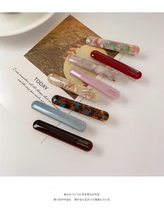 Flat lay of seven acetate hair barrettes in various marble and tortoiseshell patterns