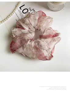 Close-up of floral print organza scrunchie with soft pink petals and elegant ruffles