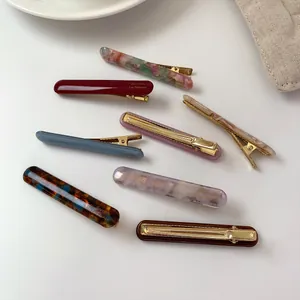 Set of eight colorful acetate hair clips in various marble patterns on white background