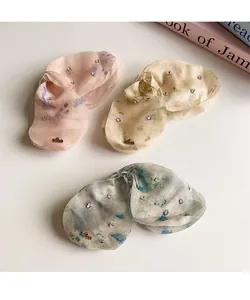 Dettaglio mollette per capelli in organza con motivi floreali e ciondoli Love dorati