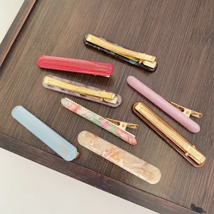 Acetate hair clip set with marble and floral patterns on a wooden display tray